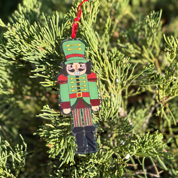 Christmas ornament shaped like a toy soldier hanging on a tree