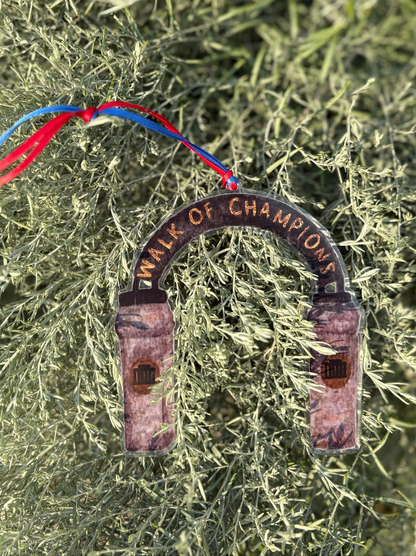 Decorative horseshoe ornament with 'Walk of Champions' text on a green leafy background